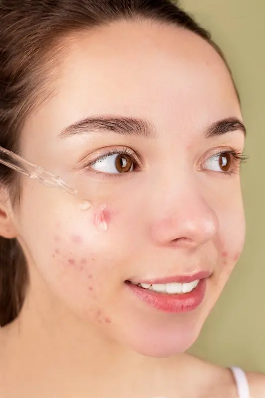 Žena nanosi serum na lice